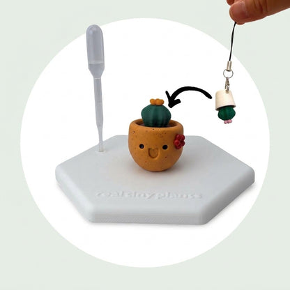 Cactus Pal keychain shown dropping into the Pumpkin Spice pot as a forever plant backup